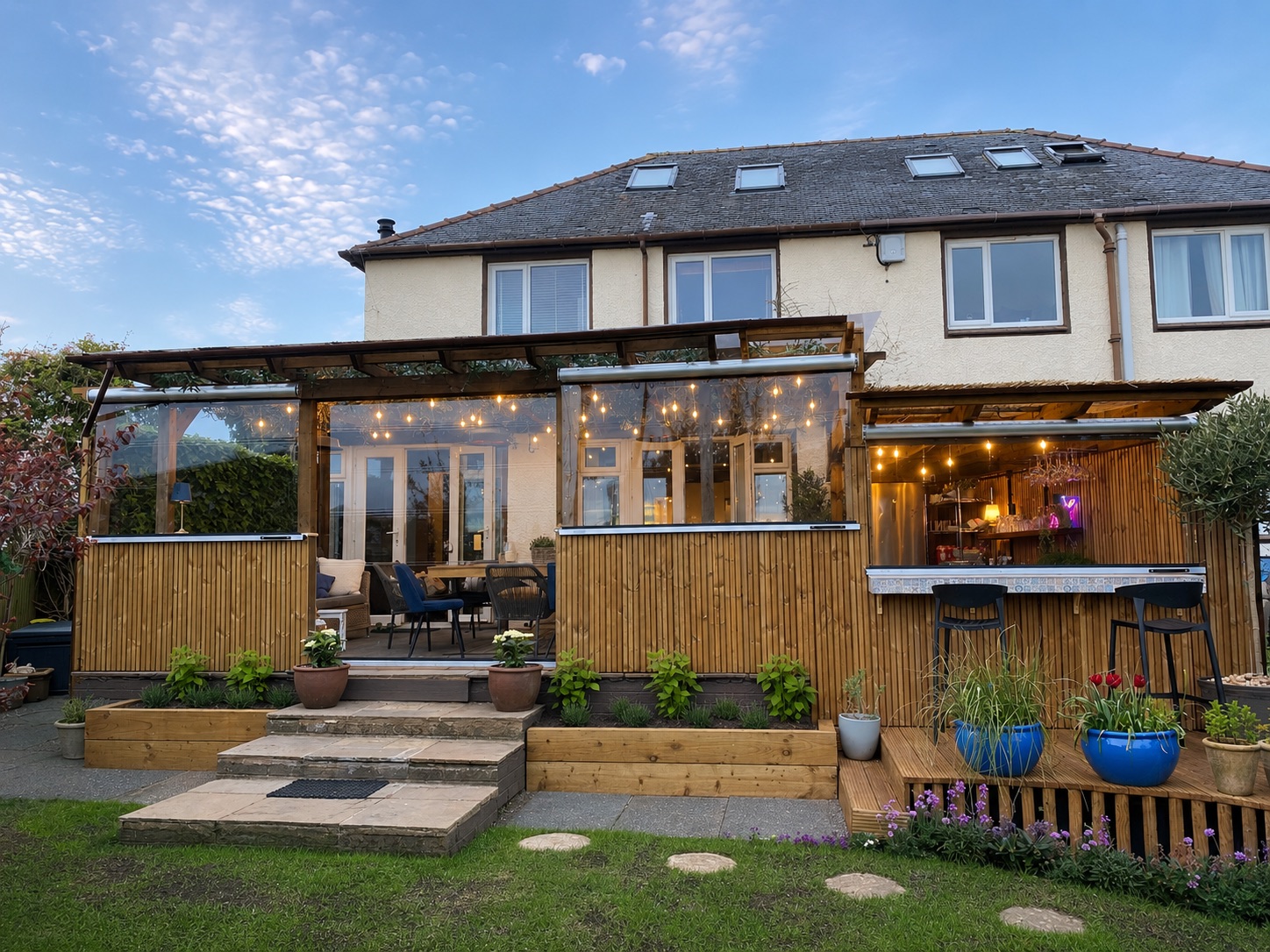 Angela McGlinchey's garden room and outdoor bar with clear roller blinds, lit in the evening