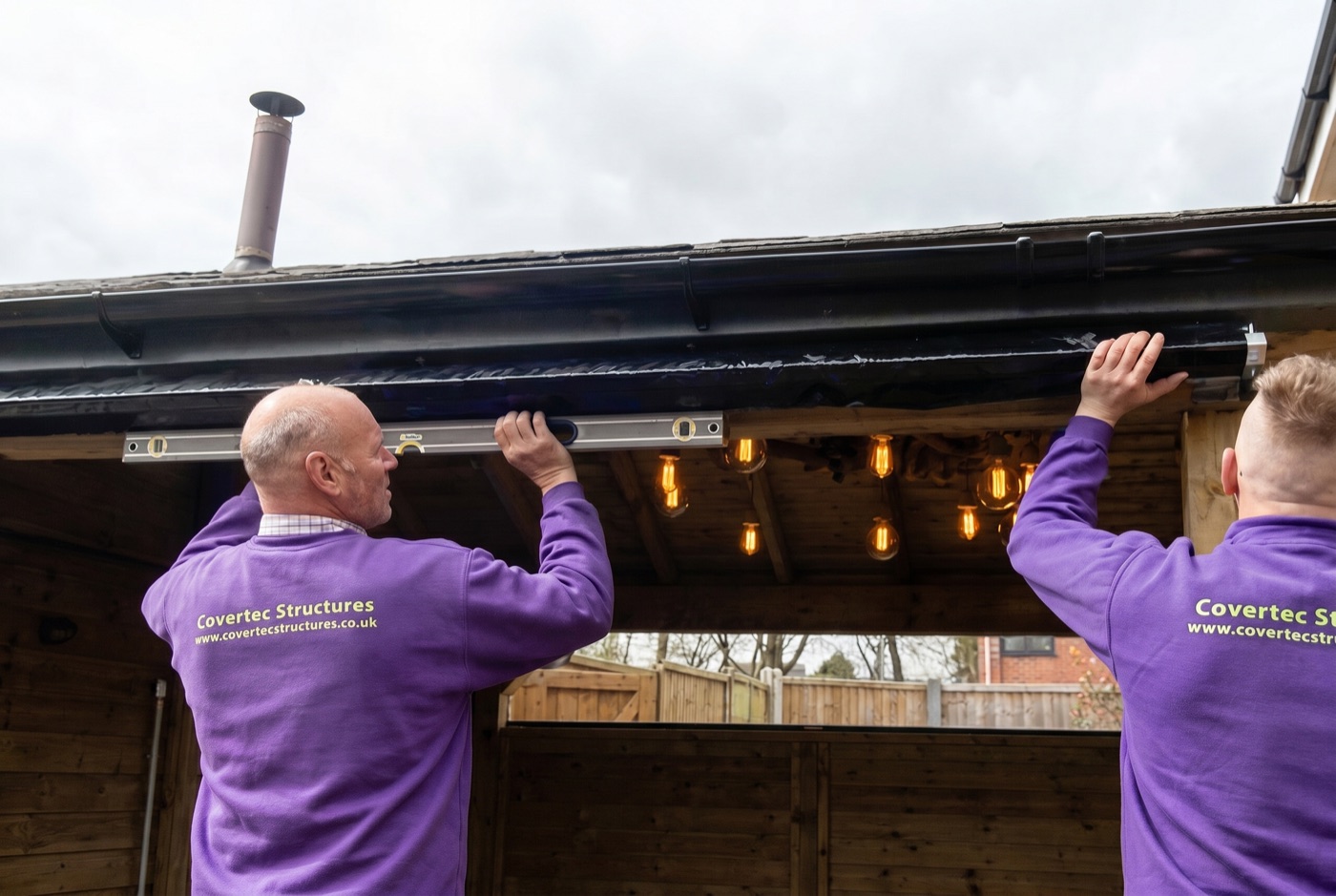Two Covertec installers levelling a blind during fitting