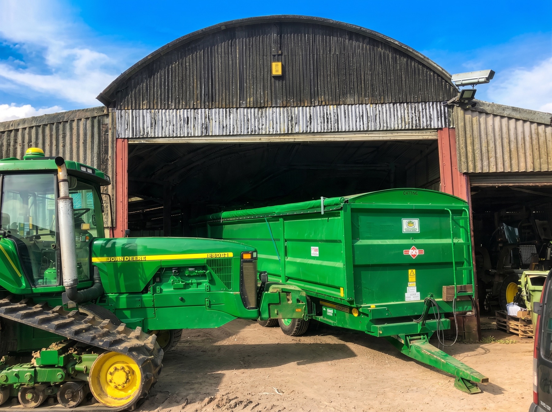 Rollover sheet kit fitted to a green farm trailer in the yard