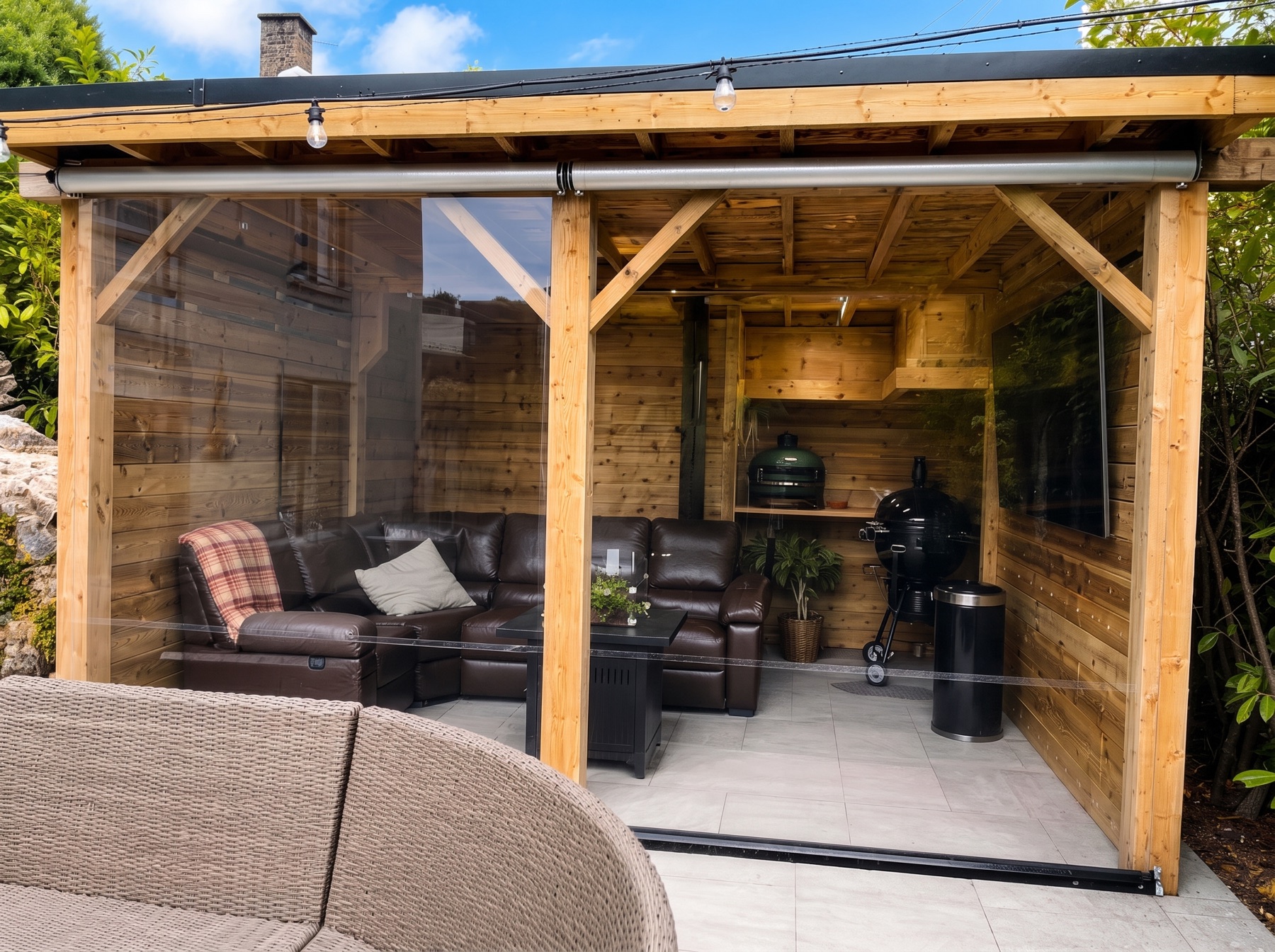 Timber garden room kept warm and dry behind clear roller blinds