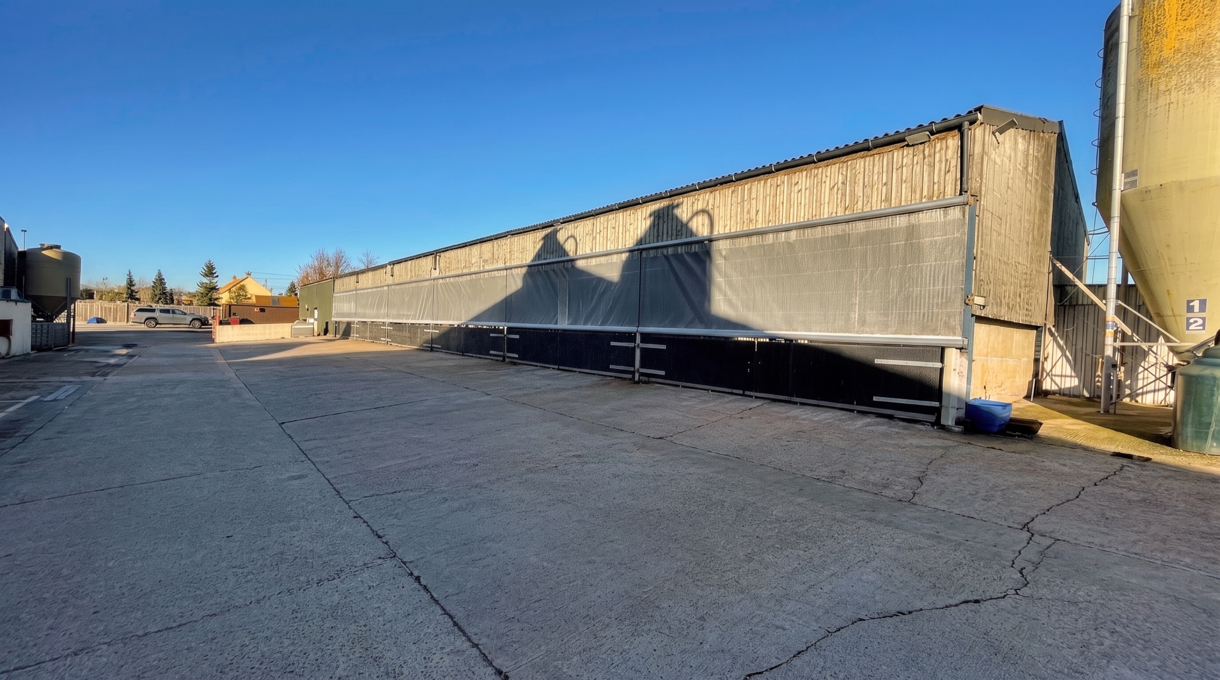 Roller blinds along the covered bays of a long industrial building