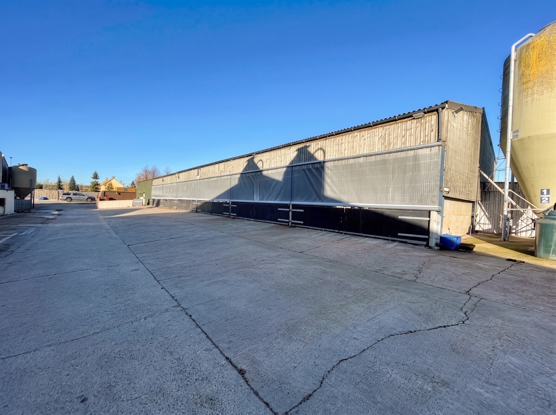Roller blinds along the covered bays of a long industrial building