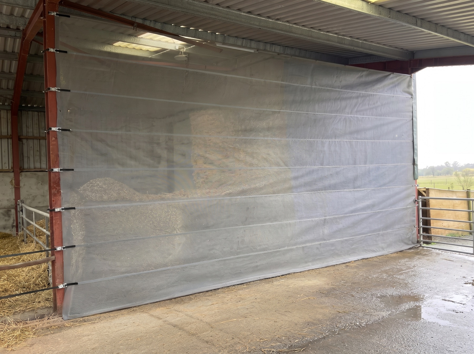 Mesh screen protecting stored materials inside a warehouse bay