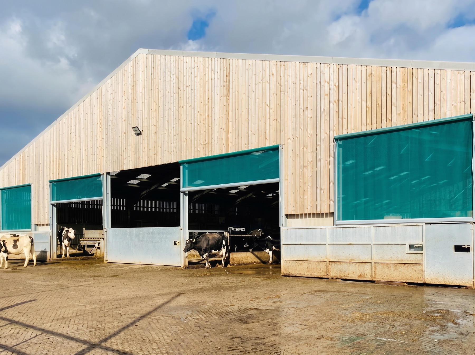 Spring roller blinds on a timber clad livestock building