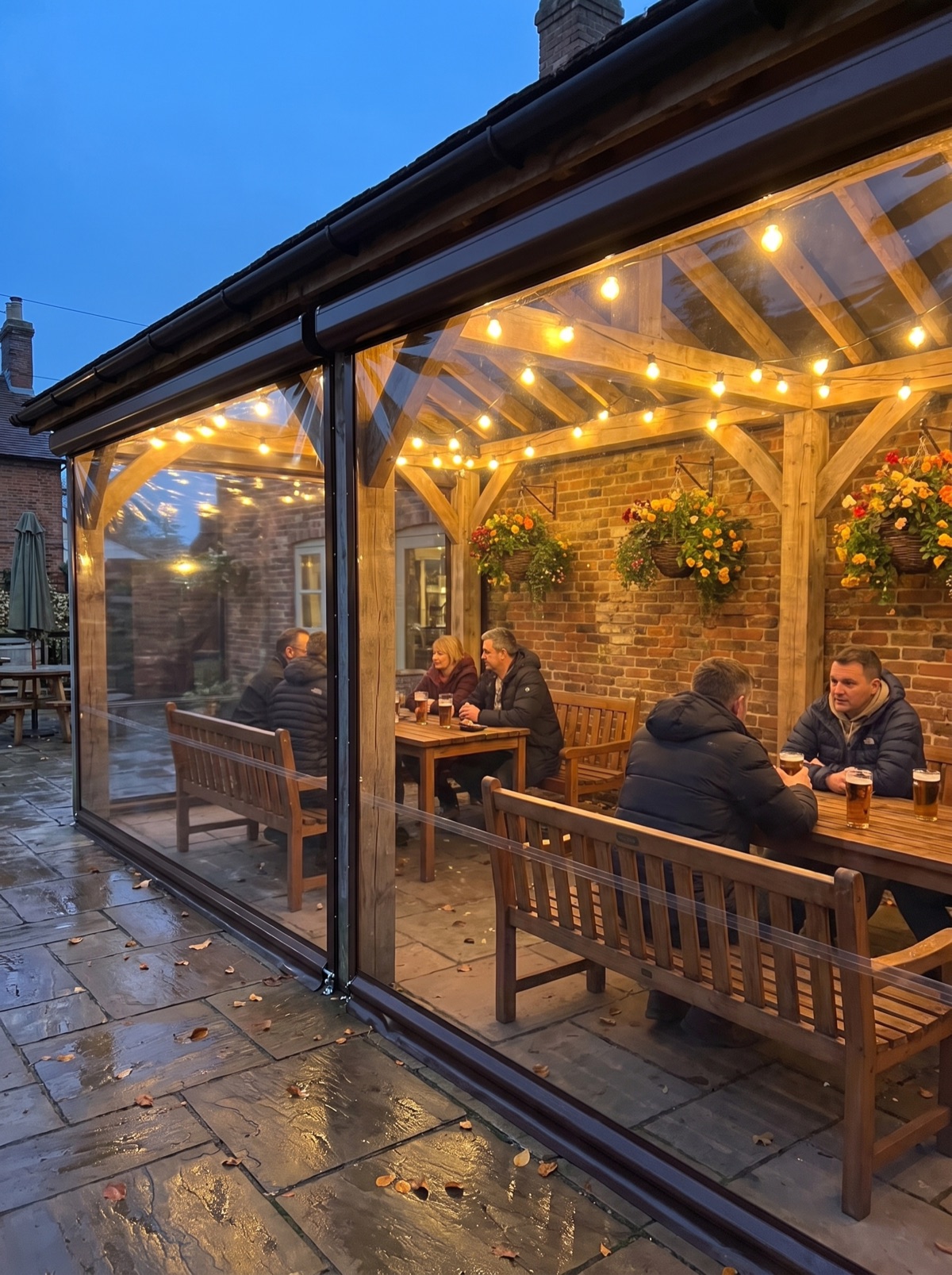 Pub garden terrace enclosed with clear roller blinds on an evening