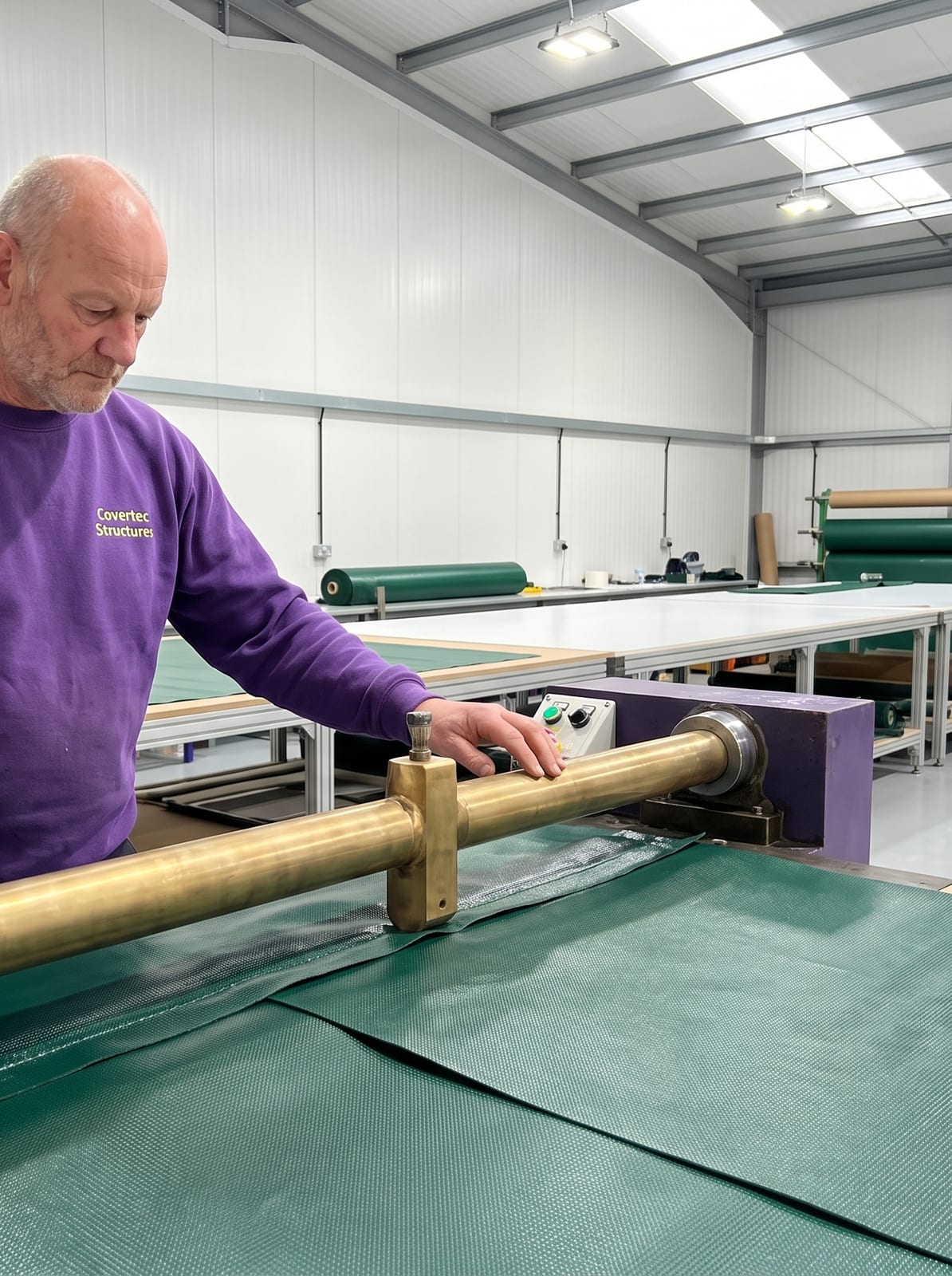A Covertec team member welding a green PVC seam on the high frequency welding machine